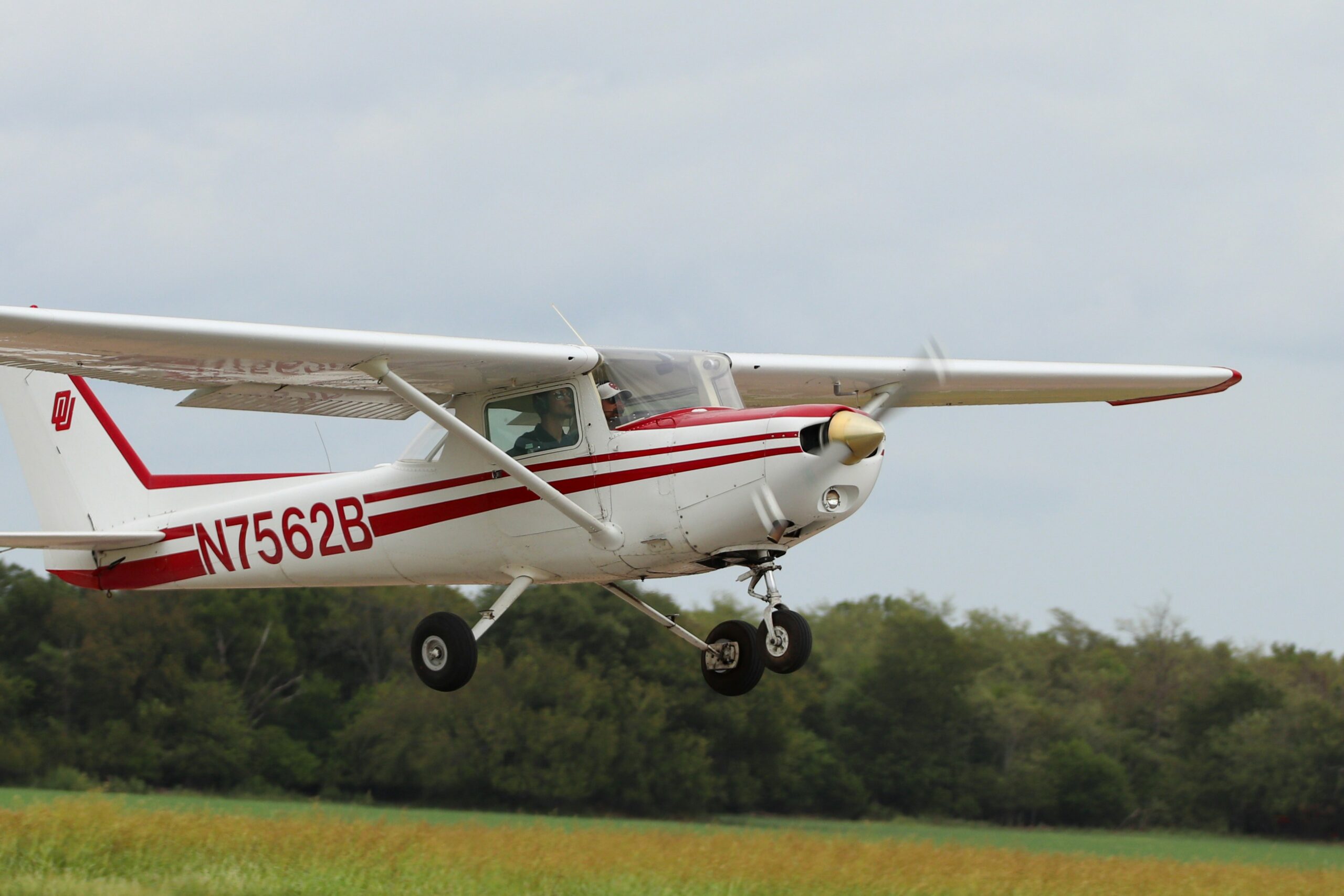 White and red plane with trees in the background
