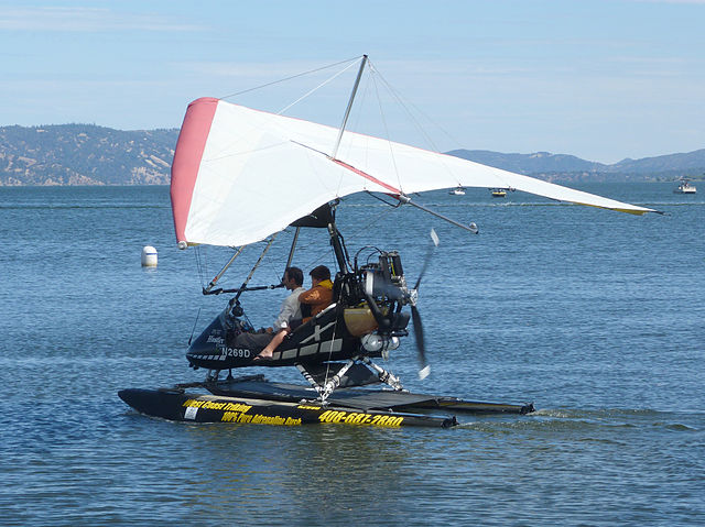 white and red plane on the water